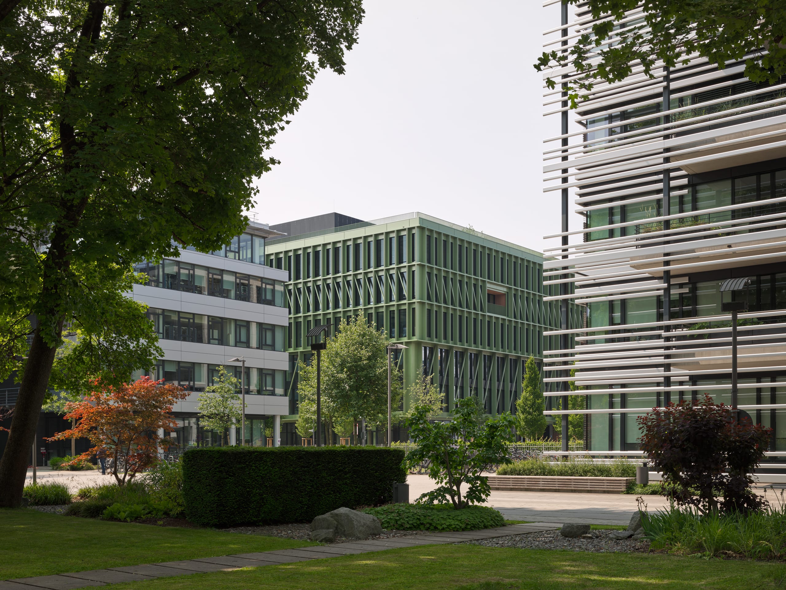 Moderne Bürogebäude mit Garten im Vordergrund.