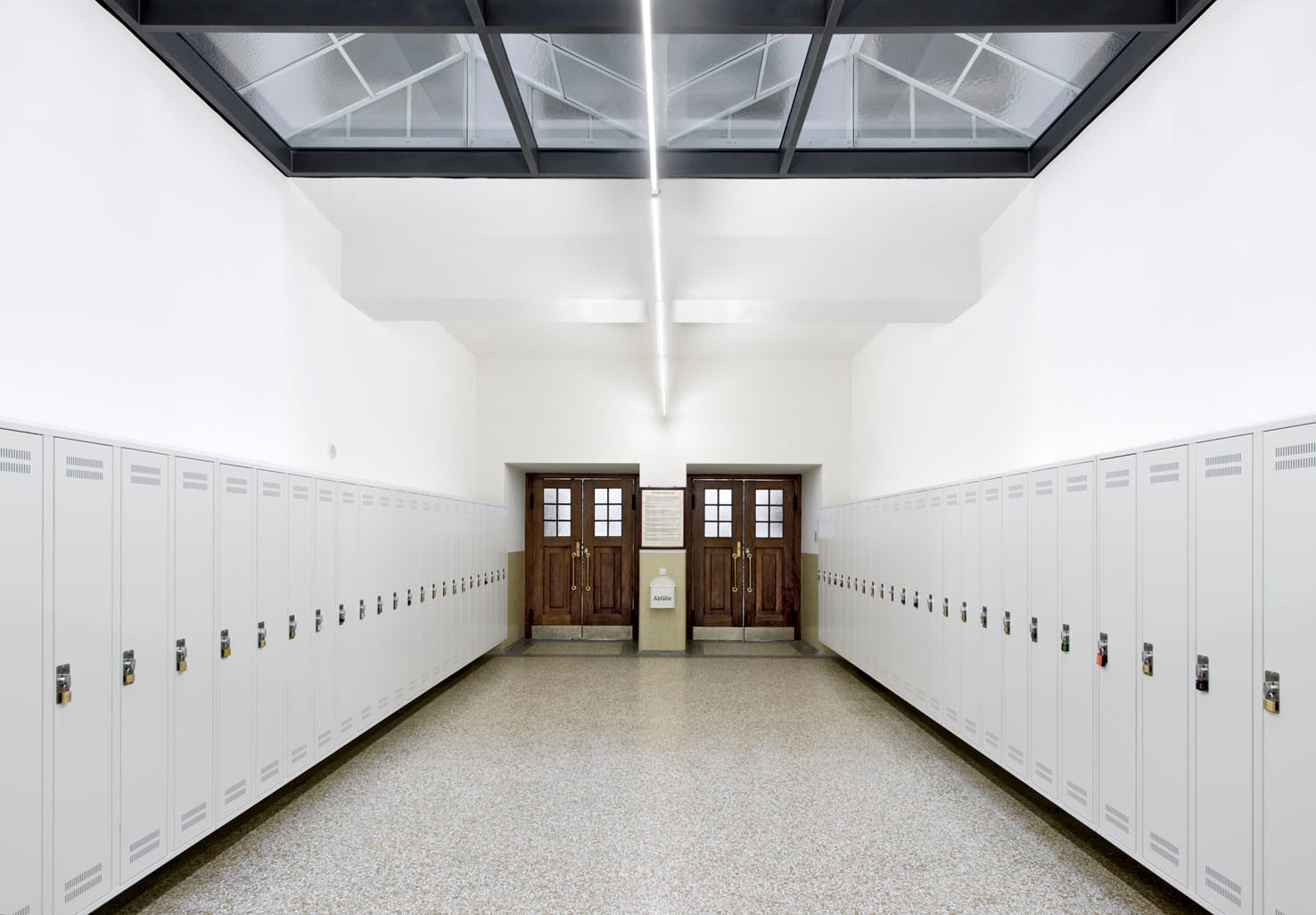 Leerer Umkleideraum mit weißen Spinden.