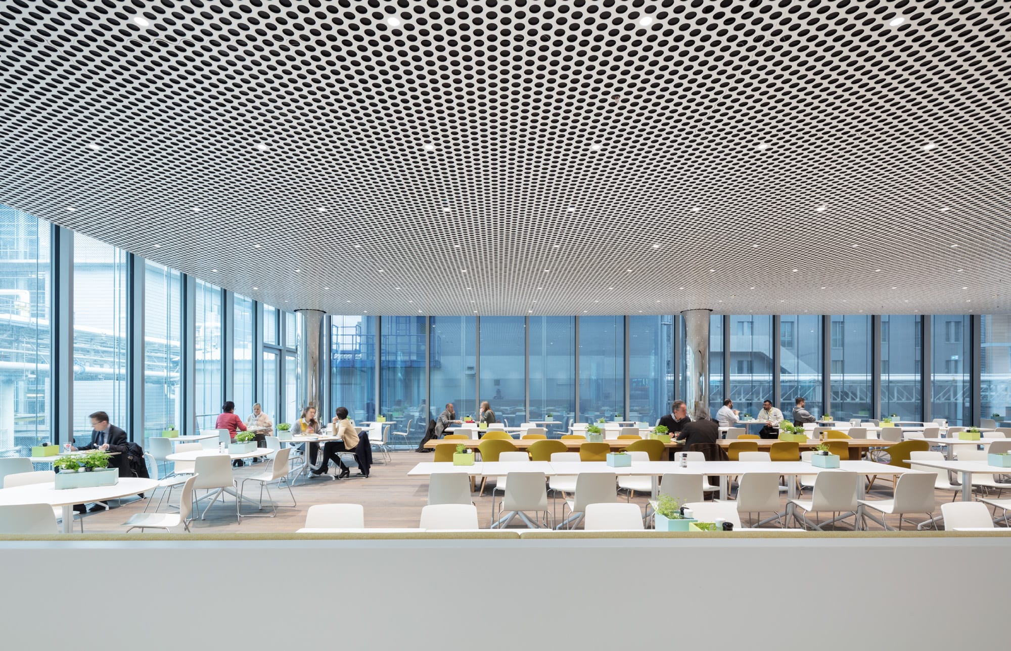 Moderne Bürokantine mit Menschen und Designerdecke.