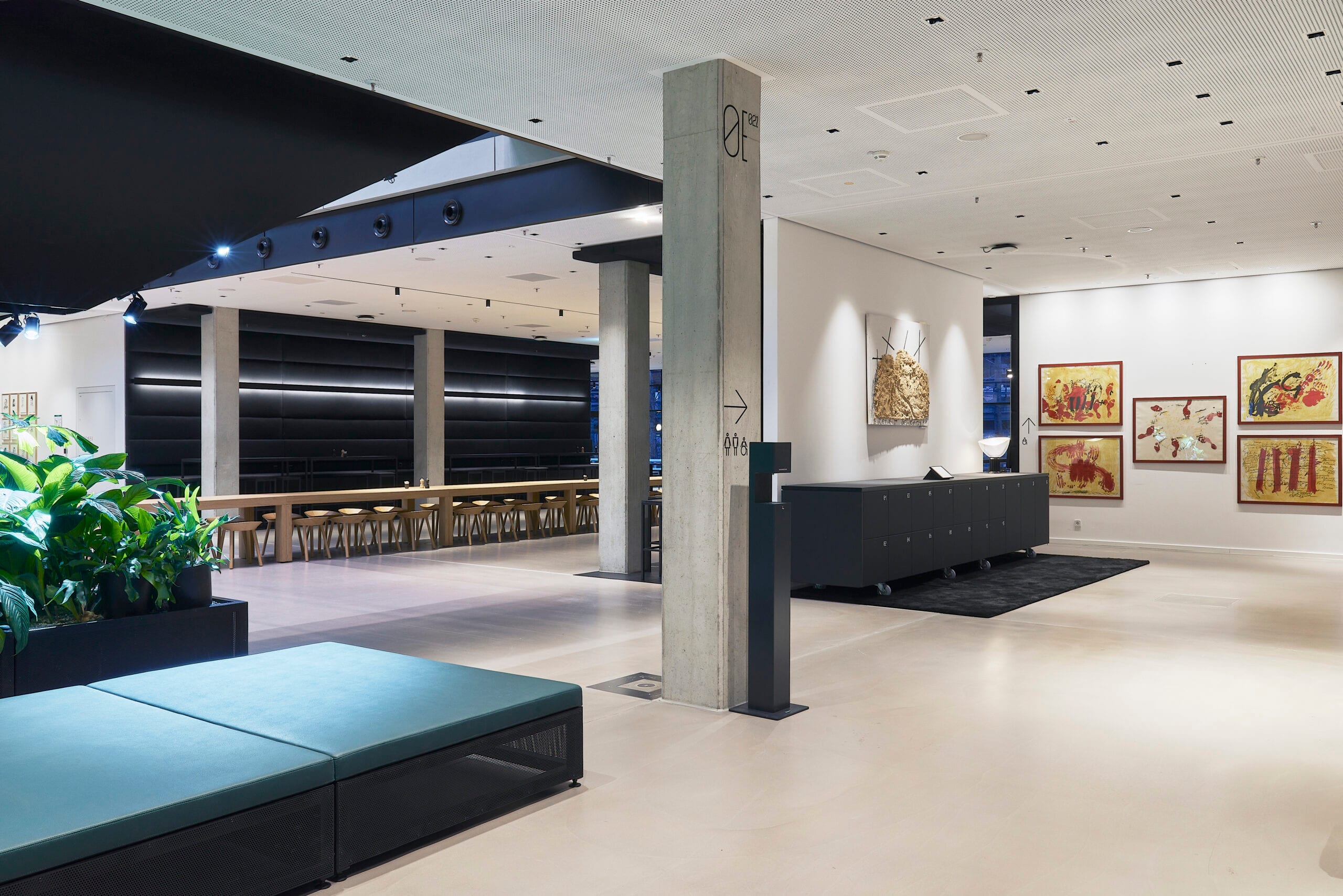 Modernes Galerie-Interieur mit Kunstwerken und Sitzgelegenheiten.