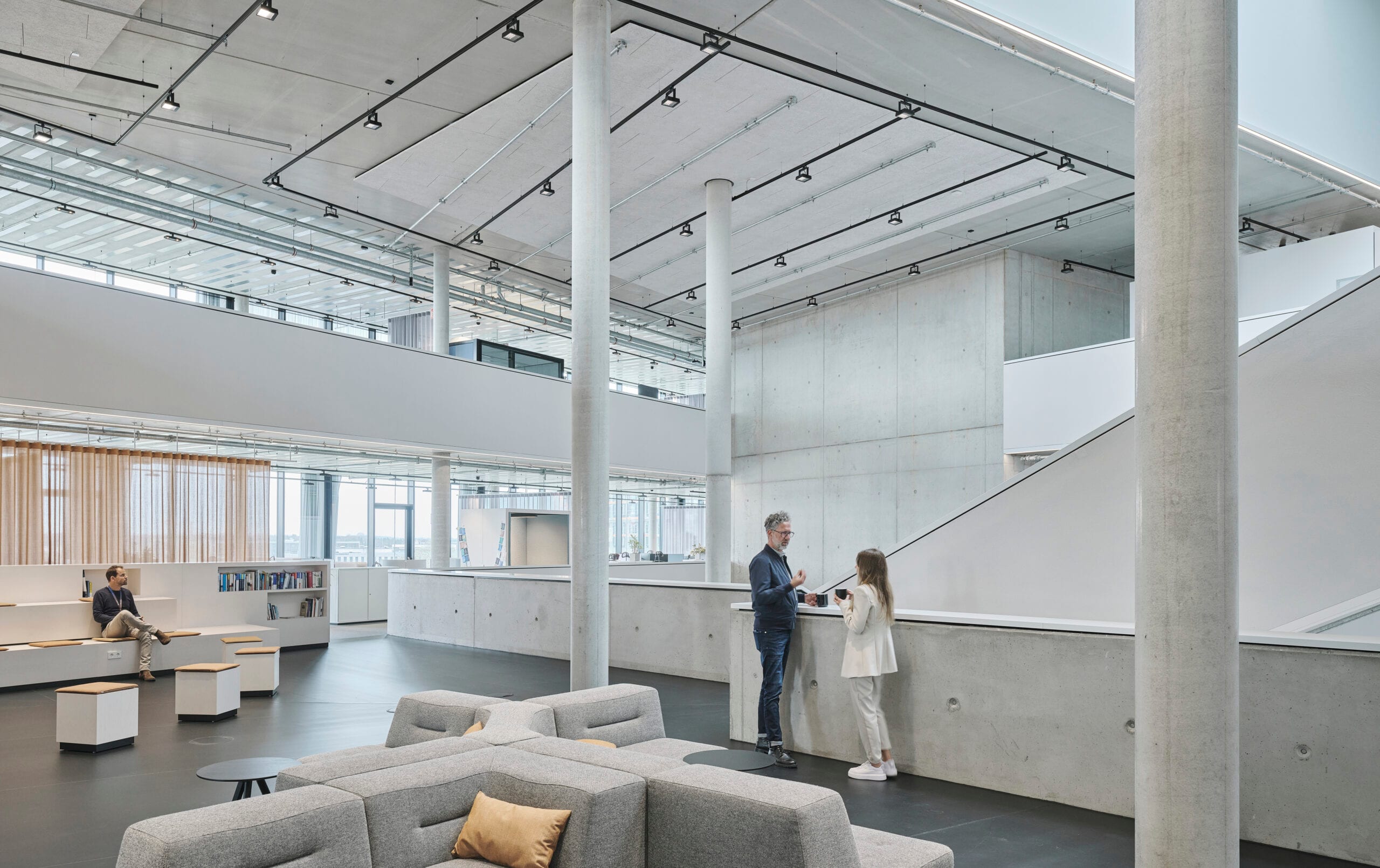 Modernes Bürointerieur mit Personen und Sitzbereichen.