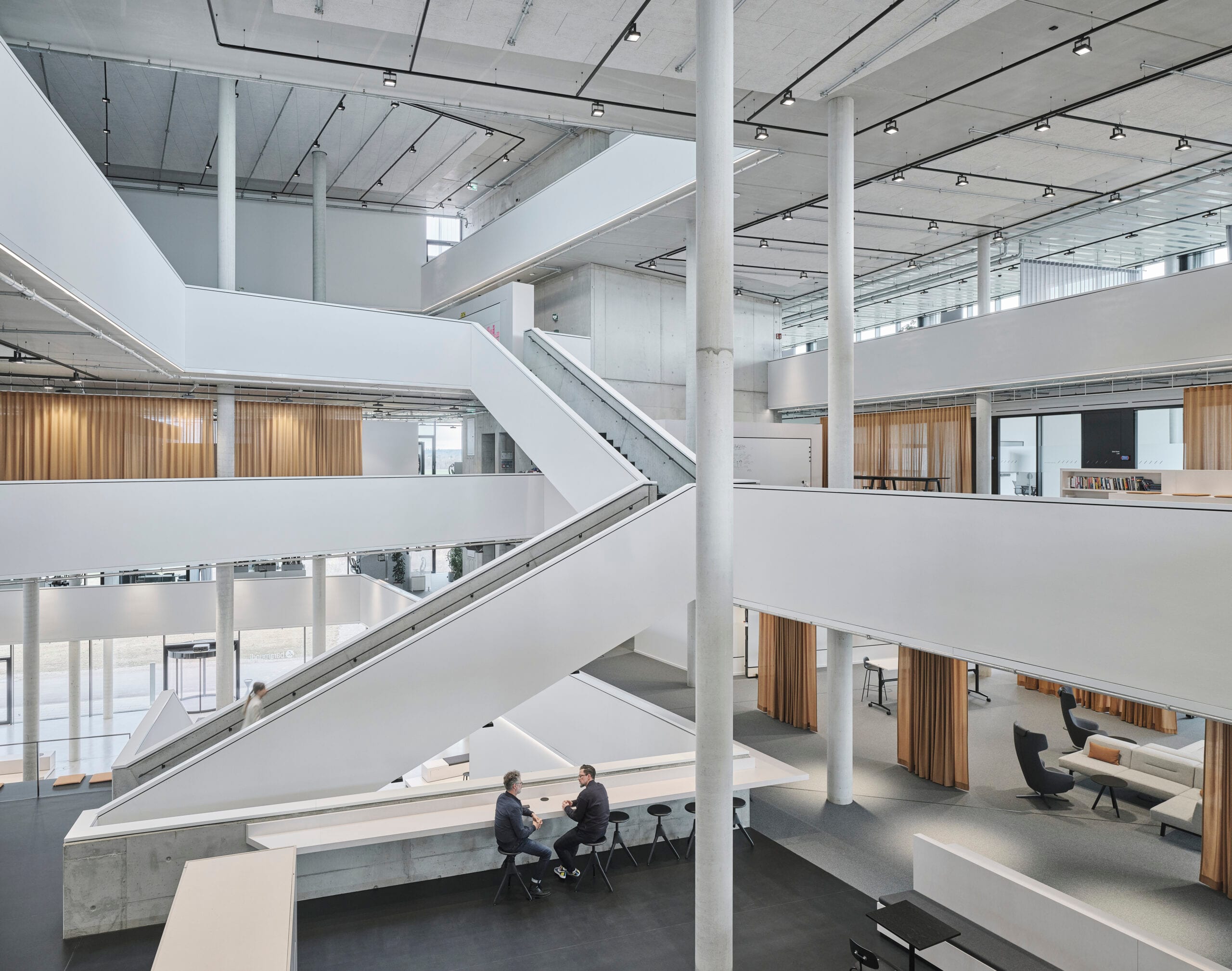 Modernes Bürogebäude mit Treppen und Sitzbereichen.