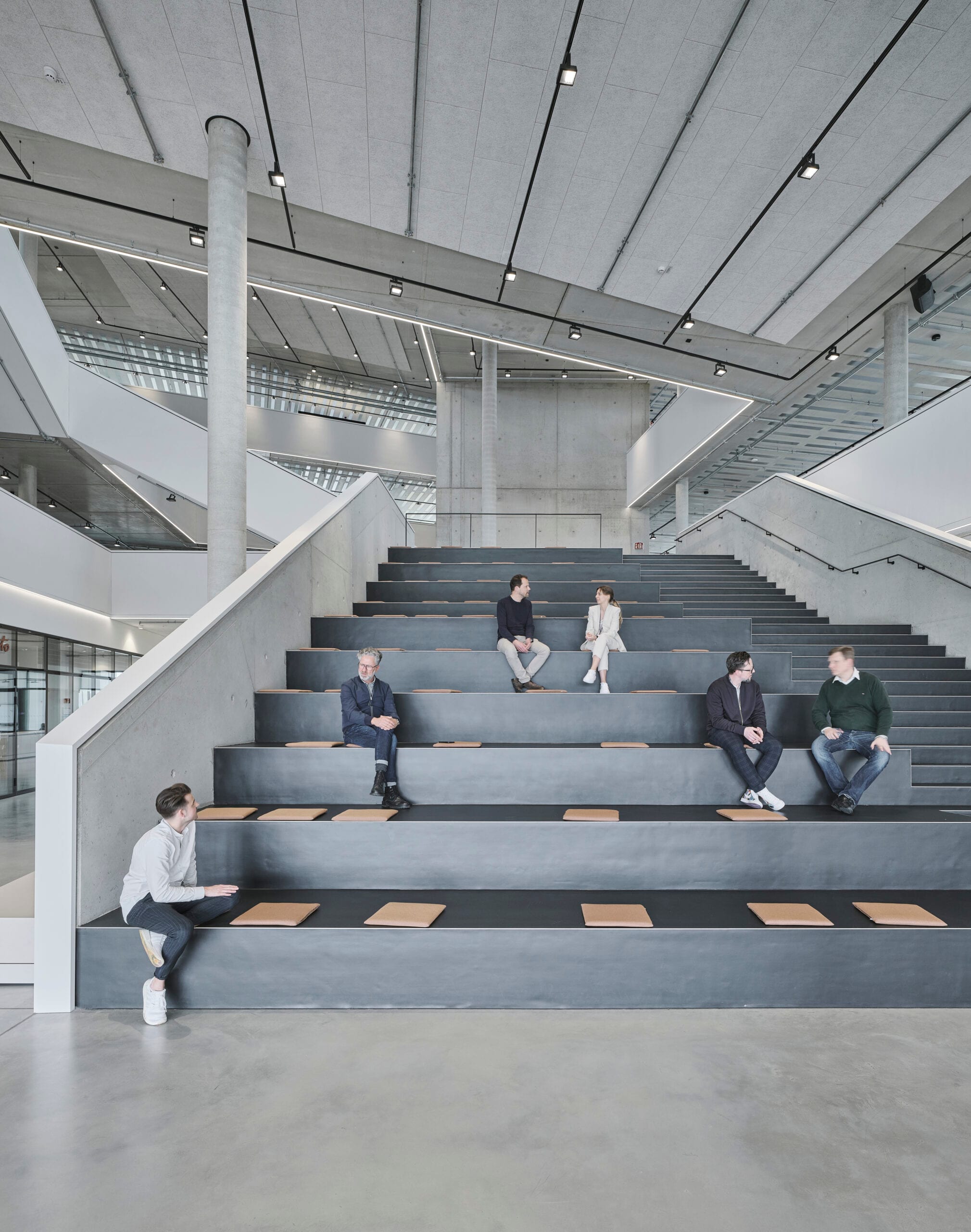 Moderne Architektur mit Menschen auf Treppensitzplätzen.