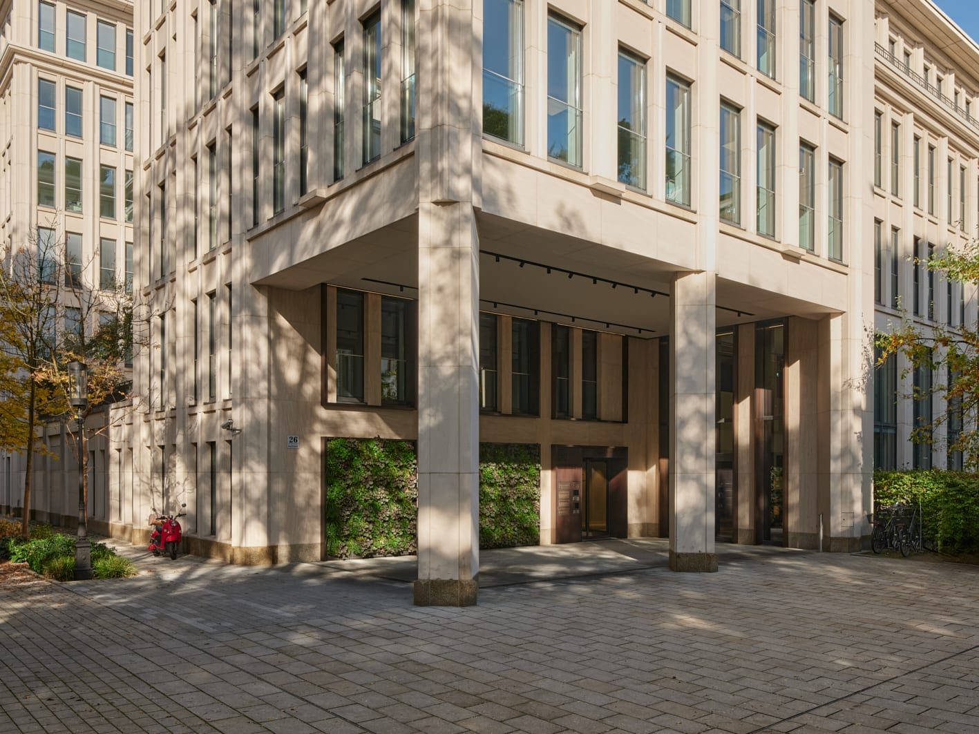 Moderne Bürogebäude mit Glasfassade und Pflanzenwand.