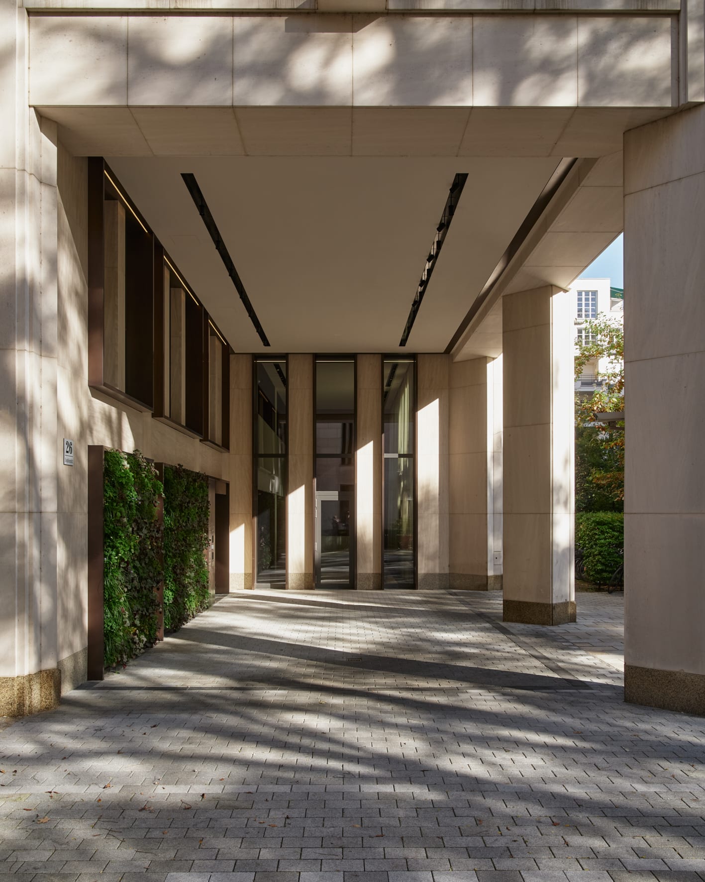 Eingang eines modernen Gebäudes mit Wandbegrünung.