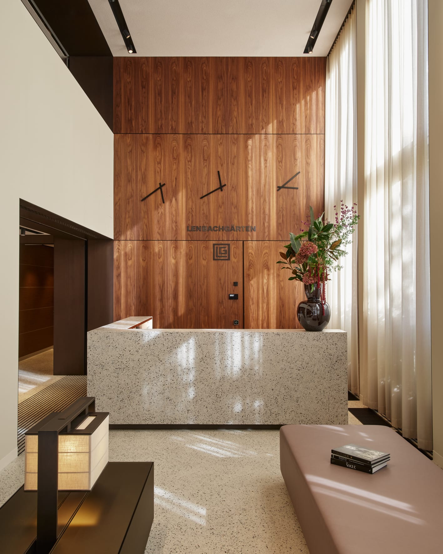 Moderne Empfangshalle mit Holzwand und Marmor-Theke.