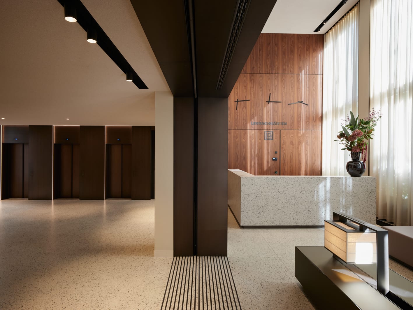 Moderner Empfangsbereich mit Holz- und Steindekor.