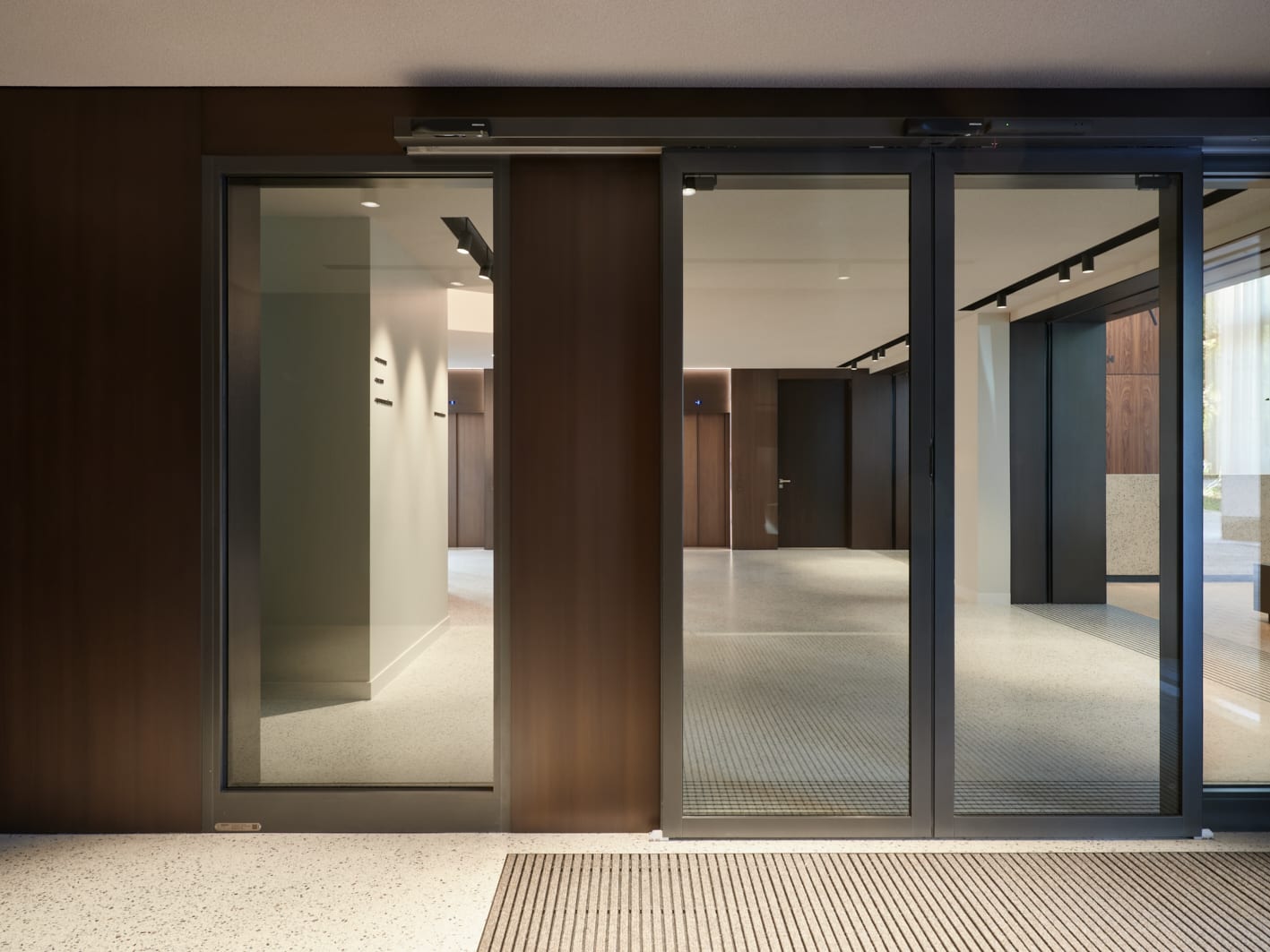 Moderner Eingangsbereich mit Glastüren und Flur