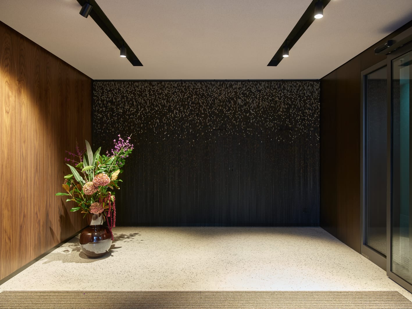 Flur mit Blumen und modernem Lichtdesign.