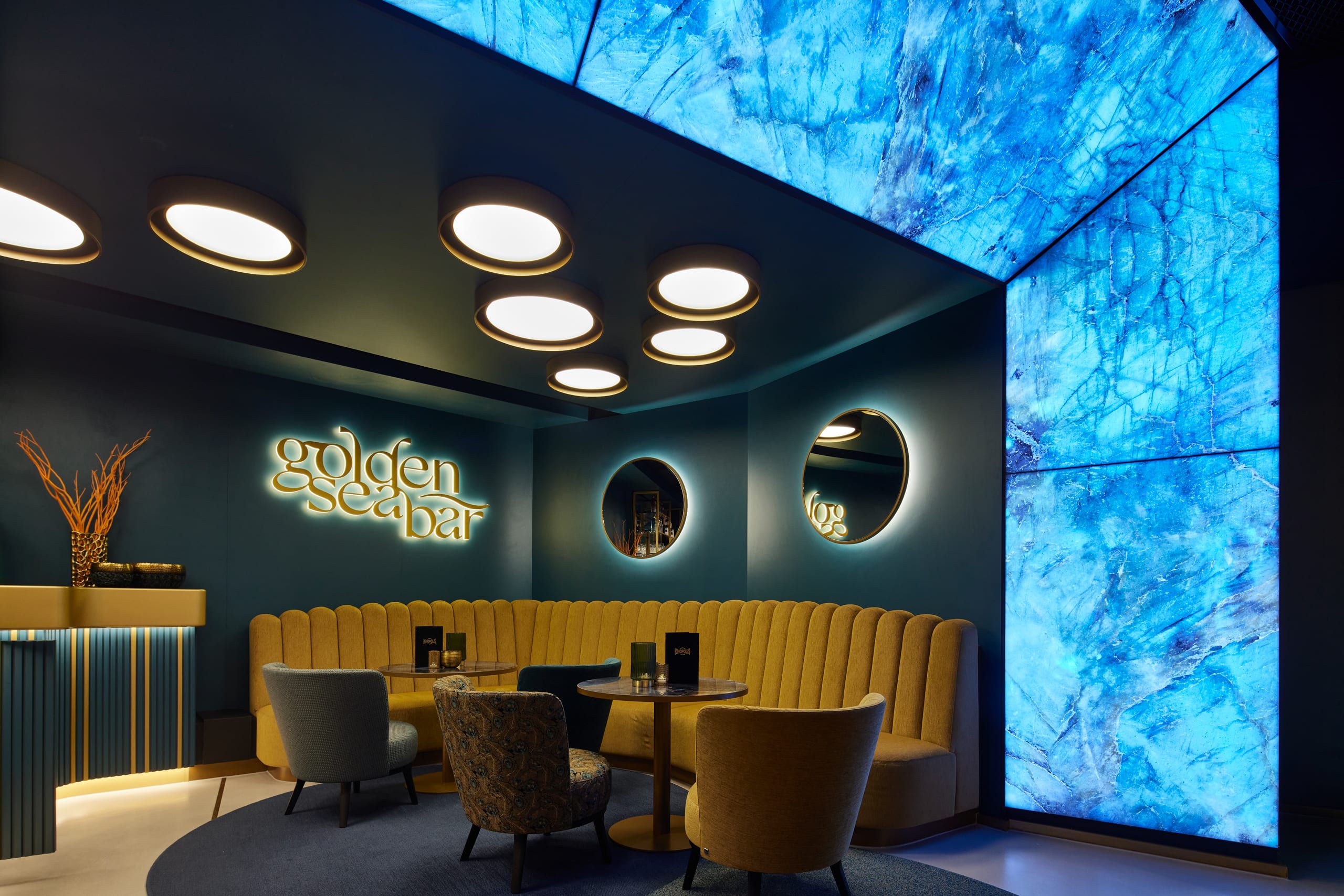 Moderne Bar mit blauer Beleuchtung und eleganten Sitzmöbeln