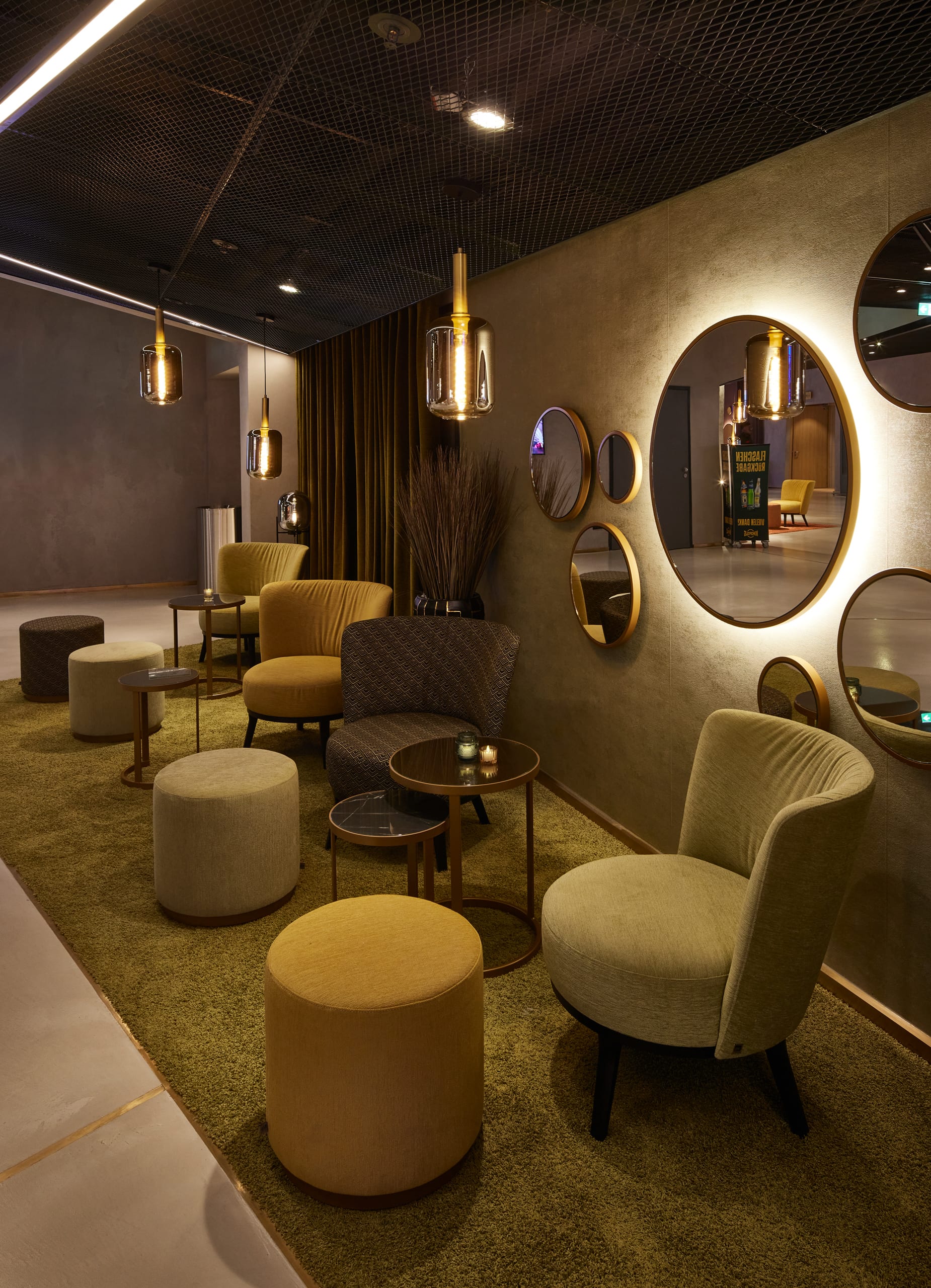 Moderne Lounge mit Sesseln, Spiegeln und warmem Licht