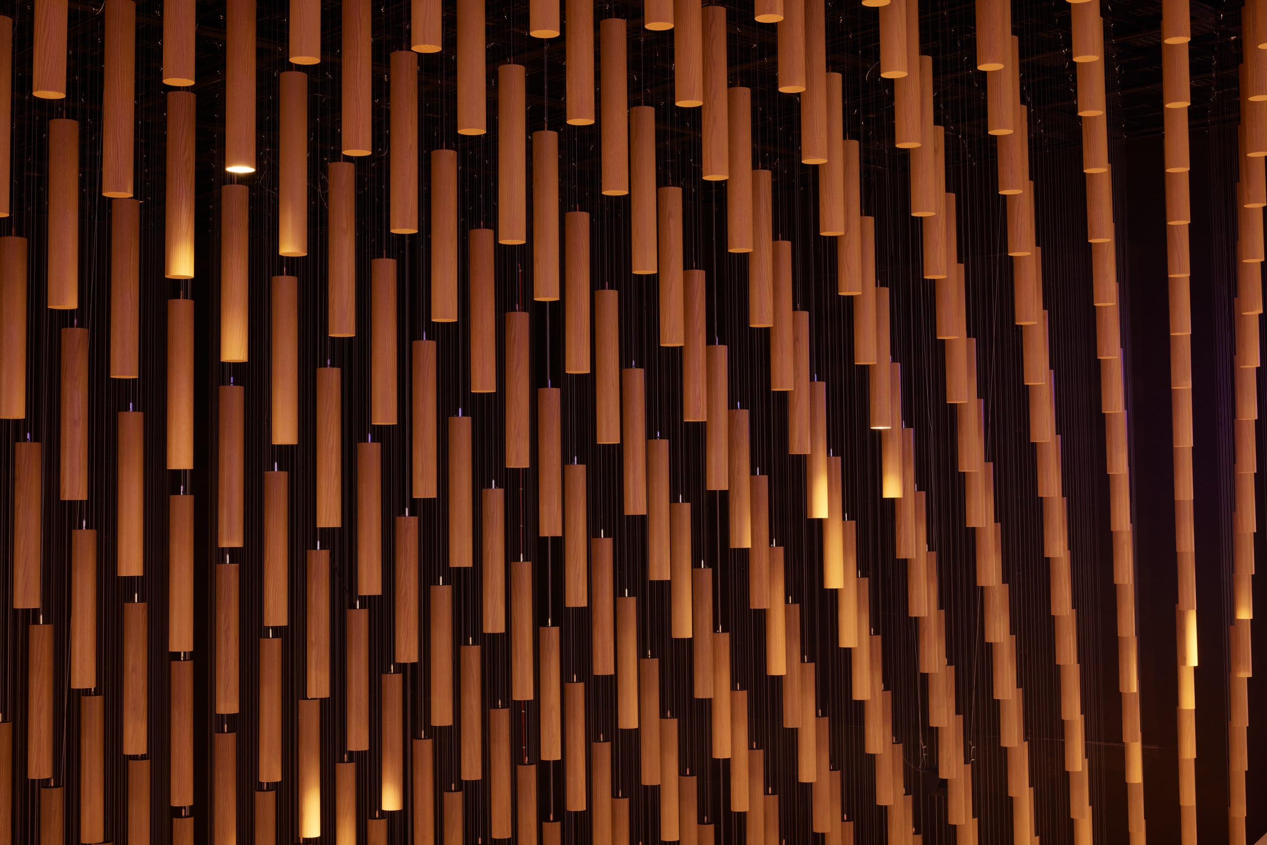 Holzzylinder hängen als dekorative Beleuchtung von der Decke