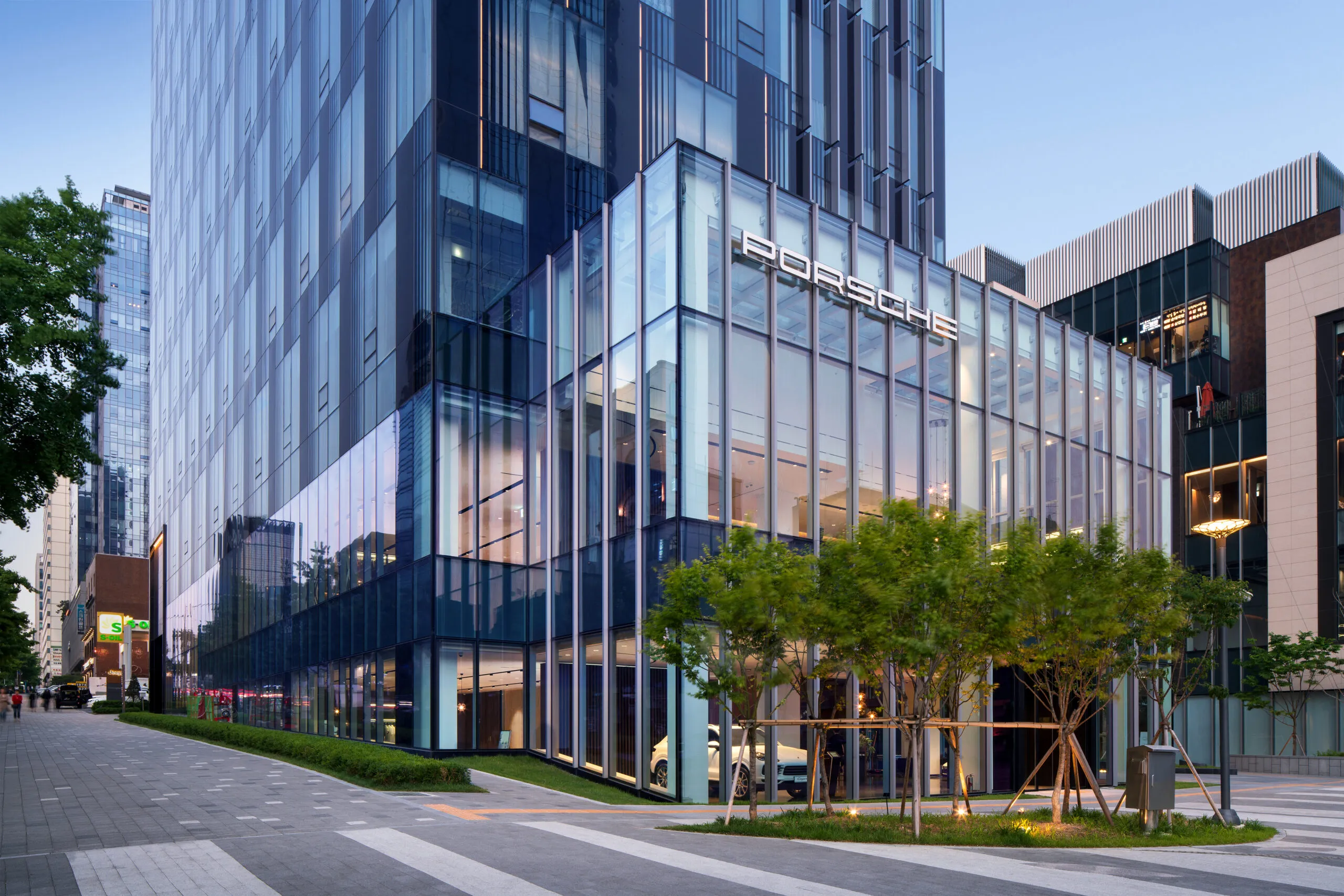 Porsche Showroom bei Dämmerung in moderner Stadtszenerie.