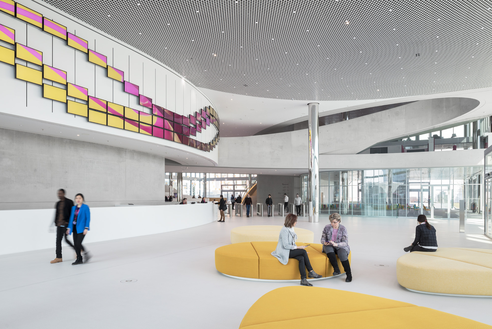 Moderne Lobby mit farbenfrohen Sitzgelegenheiten und Personen.