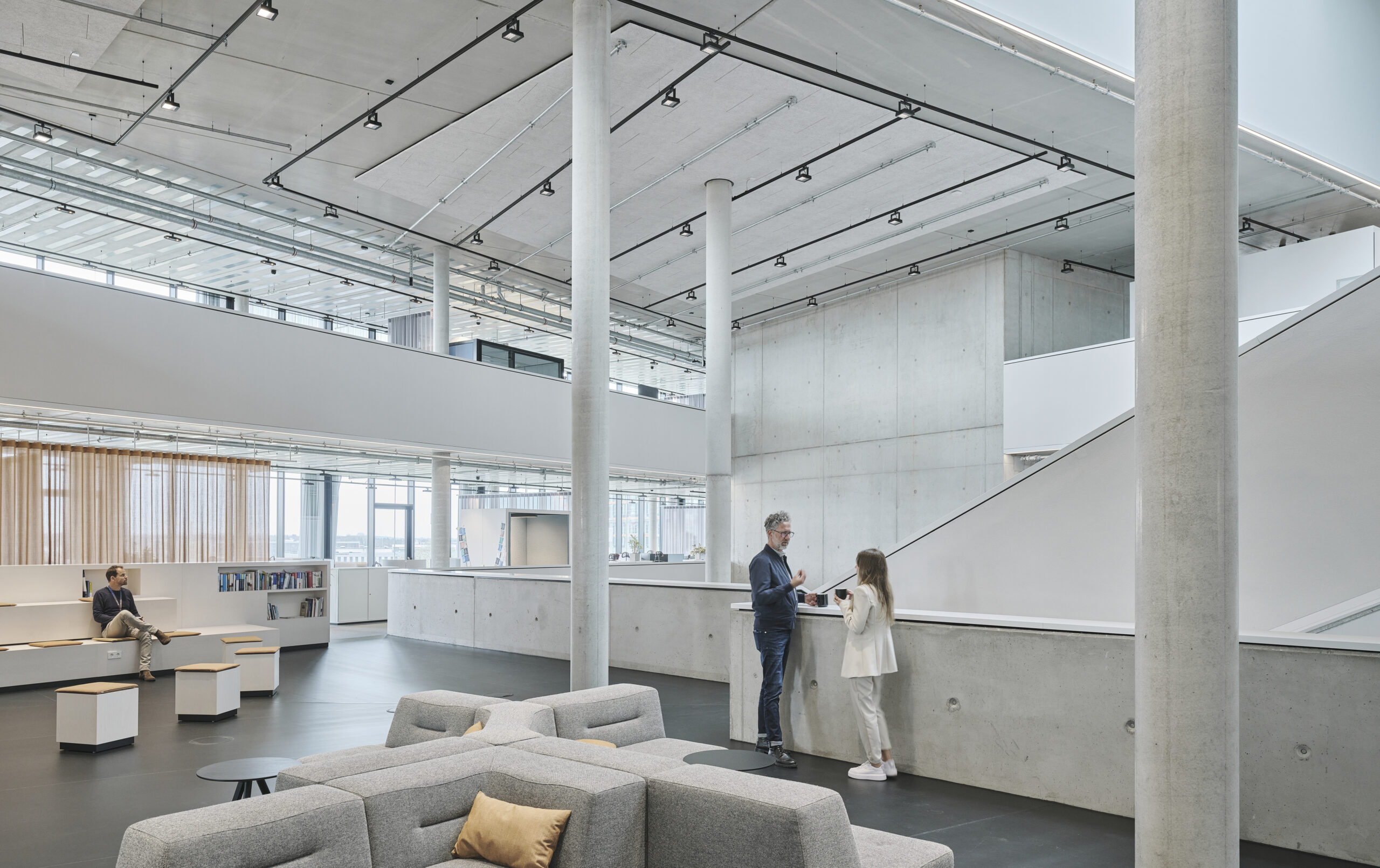 Modernes Bürointerieur mit Personen und Sitzbereichen.