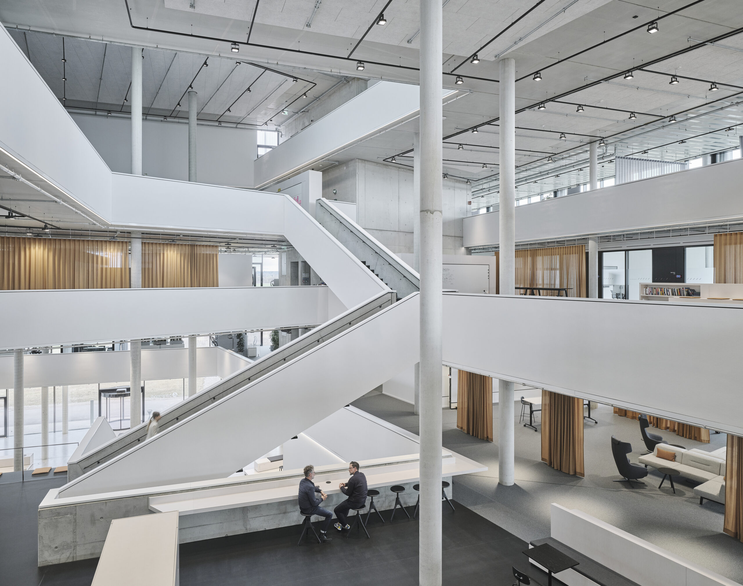 Modernes Bürogebäude mit Treppen und Sitzbereichen.