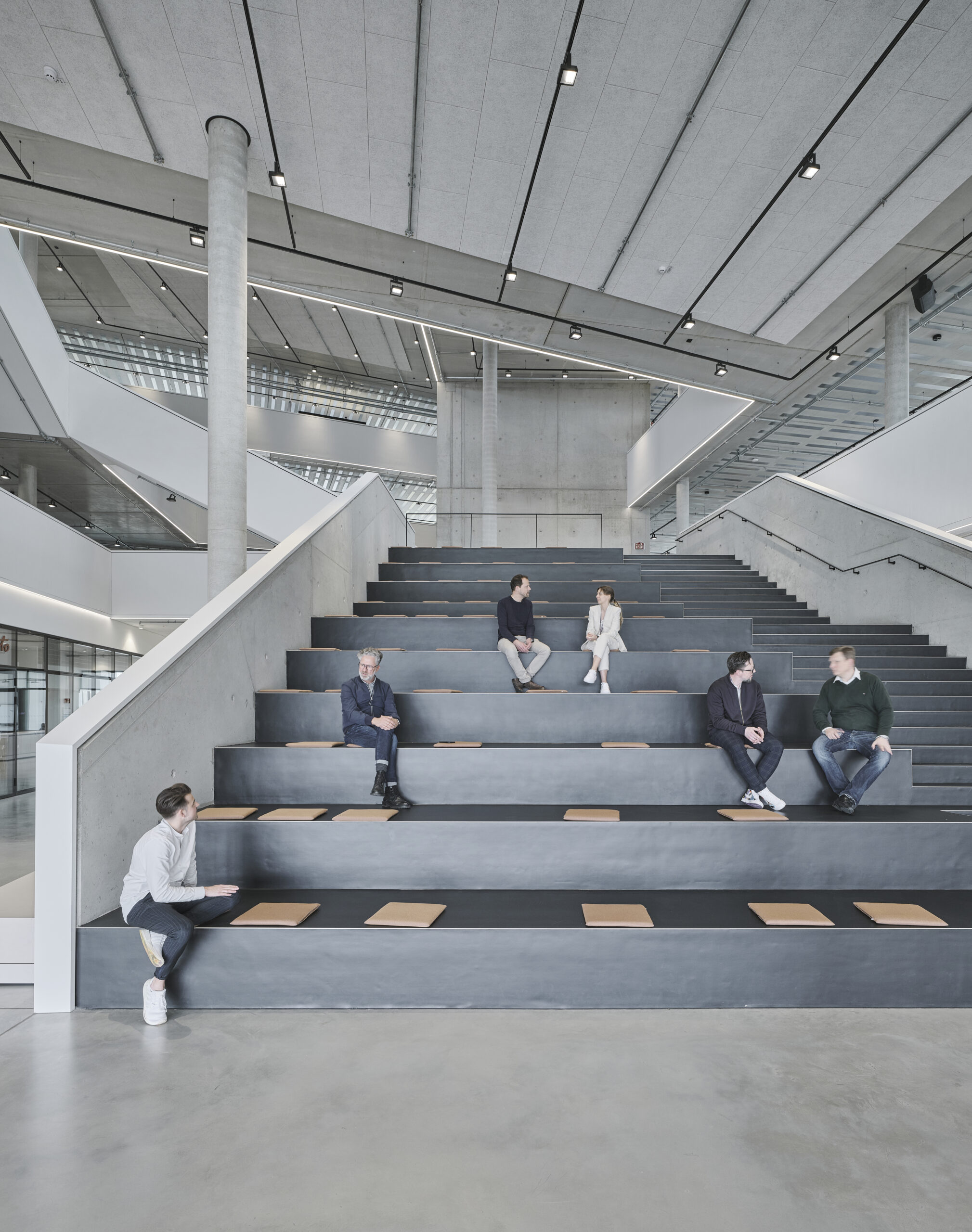 Moderne Architektur mit Menschen auf Treppensitzplätzen.